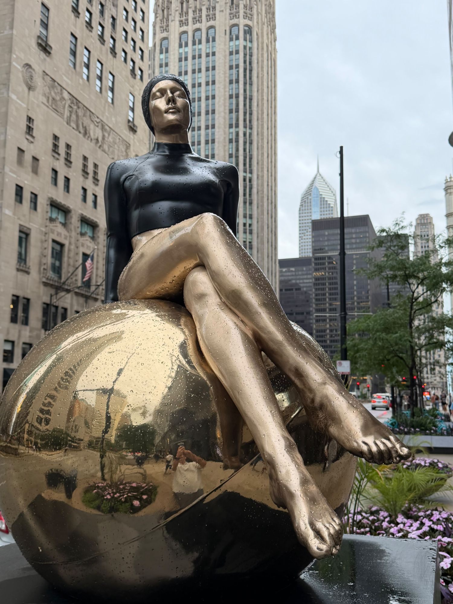 Carole A. Feuerman swimmer in black and gold seated on a golden sphere, Michigan Avenue, Chicago