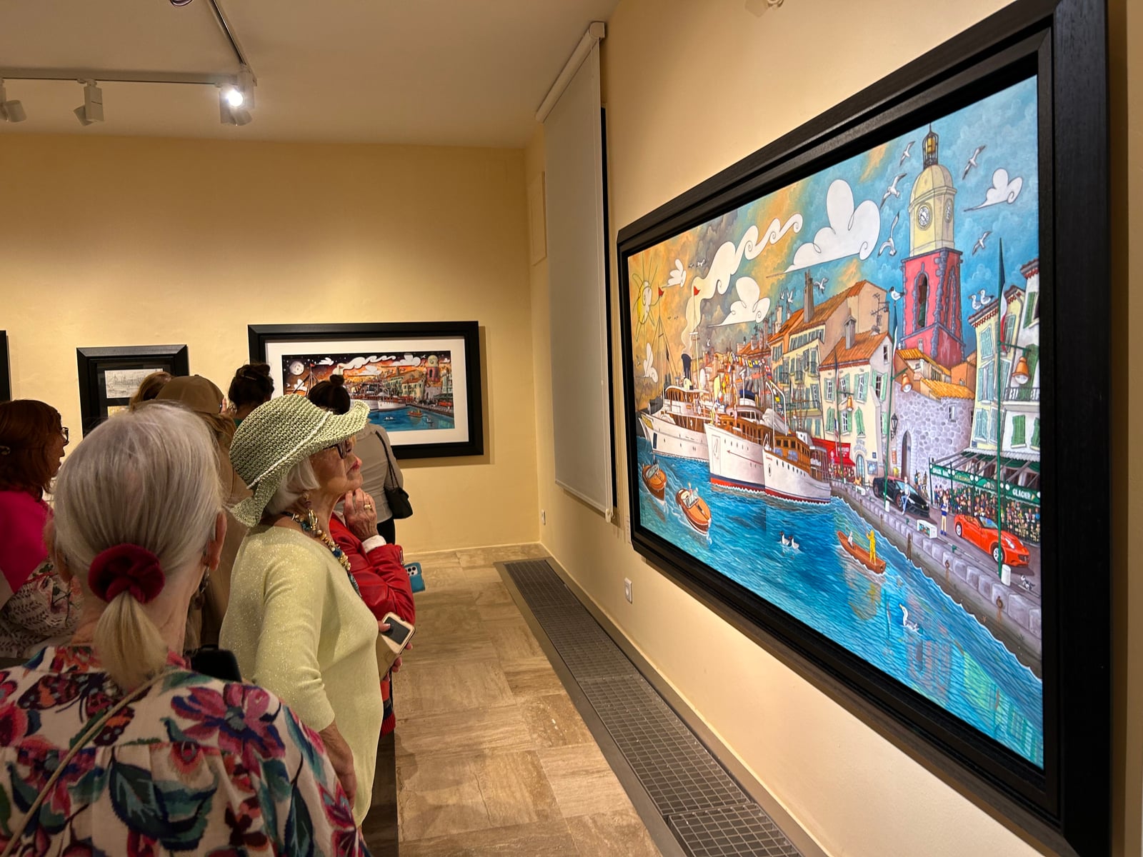 Visitors in front of Alain Godon's painting of the port of Saint-Tropez at the Musée de l'Annonciade