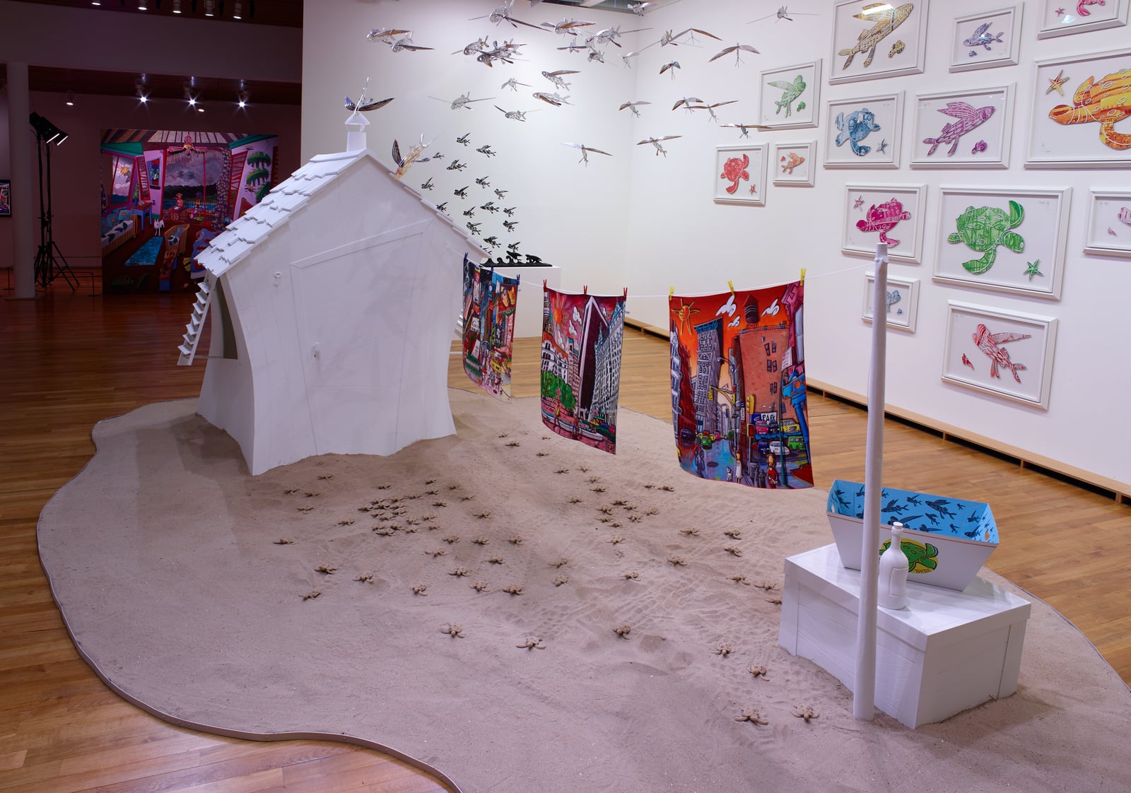Matisse-Godon exhibition view: Alain Godon's white house installation with a washing line of paintings and a flight of birds
