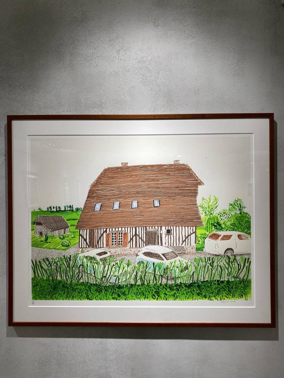 David Hockney’s In Front of House Looking South, 2019, framed and hanging on a grey wall.