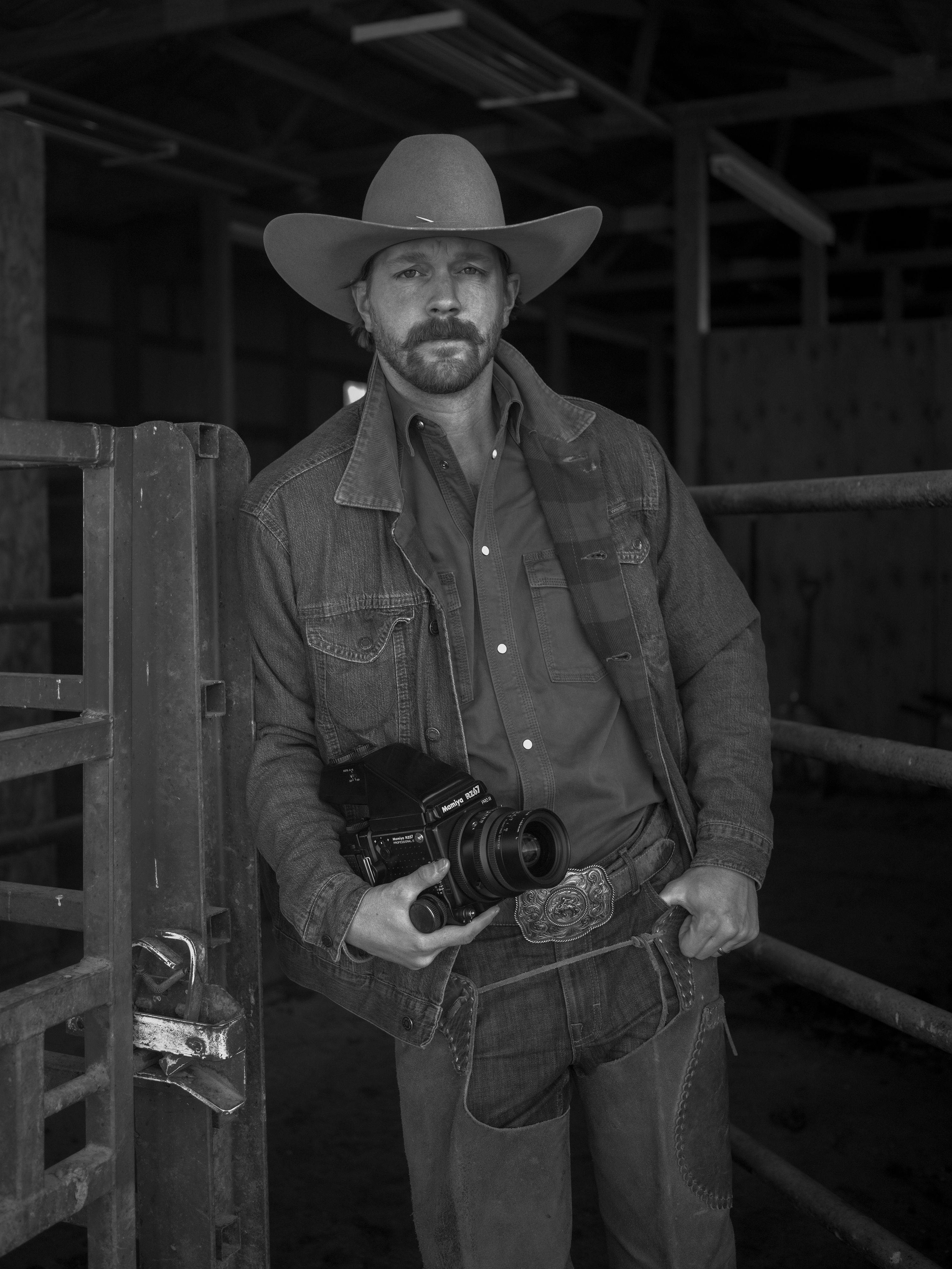 Black-and-white portrait of a photographer holding a medium-format film camera.